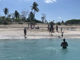 A lively beach scene with families enjoying the sun and water, showcasing a perfect day of fun and relaxation by the shore.