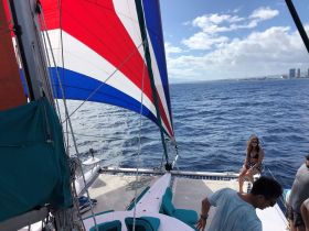 Guests enjoy a sunny day sailing on a catamaran, capturing the essence of ocean adventures and relaxation.