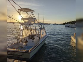 A picturesque view of a fishing boat docked at sunset, showcasing its structure against a serene water backdrop — perfect for fishing enthusiasts and sunset lovers.