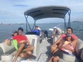 A joyful family enjoys a day on a pontoon boat, capturing moments of togetherness and fun on the water.