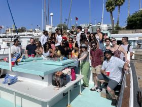A lively group of friends gathers on a boat, enjoying snacks and drinks, perfect for a fun day out on the water.