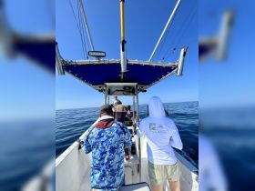 A group of people aboard a fishing boat enjoy a day on the open ocean, showcasing the excitement of fishing adventures.