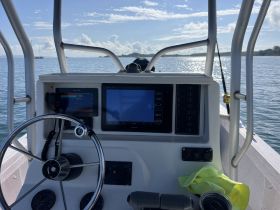 A detailed view of the helm and console of a boat, showcasing the navigation equipment and steering wheel, perfect for those interested in boating technology.