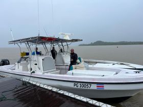 A center console boat is docked with crew members preparing for a fishing trip, showcasing the vessel's design and readiness for adventure.