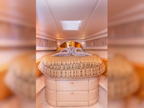 A cozy cabin interior featuring a beautifully made bed with towel swans, perfect for romantic getaways on the water.