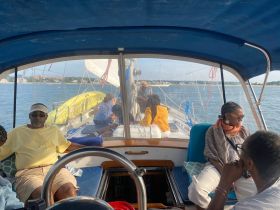 A cozy interior view of a sailboat featuring guests relaxing in the cabin, showcasing the perfect setting for a leisurely day on the water.