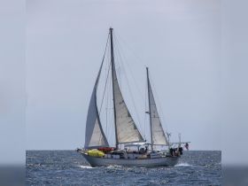 A beautiful sailboat named 'Tandem' gracefully sails through the open waters, showcasing its impressive sails and structure — perfect for sailing enthusiasts.