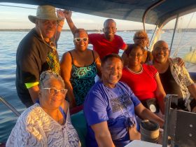 A joyful group of friends enjoys their time aboard a boat, capturing the essence of camaraderie and celebration on the water.