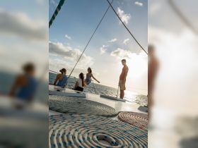 A group of friends enjoys a beautiful sunset aboard a sailboat, capturing the essence of a perfect day on the water.