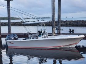 A sleek speedboat docked at the marina, showcasing its modern design and fishing gear — perfect for water adventures and fishing trips.