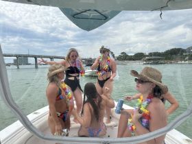 A lively group of friends enjoys a fun day on the water, celebrating with drinks and laughter aboard a boat — perfect for summer parties and memorable outings.