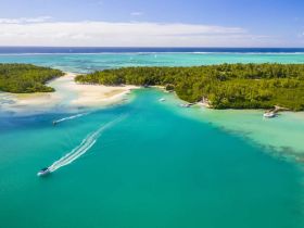 A stunning aerial view of a tropical coastline featuring turquoise waters and lush greenery, perfect for showcasing the beauty of island destinations.