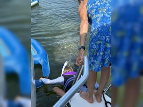 A child prepares to snorkel while being assisted by an adult, showcasing a fun water activity perfect for family adventures.