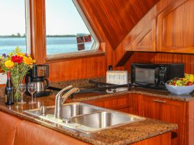 A beautifully designed boat kitchen featuring modern appliances, a cozy dining area, and scenic views of the water, perfect for onboard meals and gatherings.