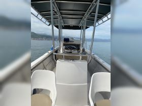Interior view of a boat's helm area, showcasing the steering console and seating arrangements — ideal for navigating the waters.