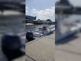 A sleek speedboat docked at a marina, showcasing its powerful Yamaha engine and fishing gear, perfect for a day on the water.