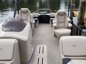 Interior view of a well-appointed boat cabin featuring comfortable seating and a helm, perfect for relaxing on the water.