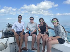 A group of kids enjoys a sunny day on the boat, showcasing the fun and excitement of a day out on the water.
