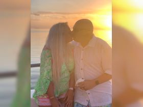 A couple shares a romantic kiss at sunset, creating a perfect backdrop for memorable moments on the water.