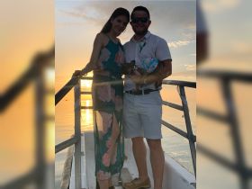 A couple poses together at sunset on a boat, capturing a romantic moment with their pet — perfect for memorable celebrations on the water.