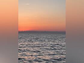A serene sunset over the ocean, capturing the tranquil beauty of the water as day transitions to night — perfect for peaceful evening boat cruises.