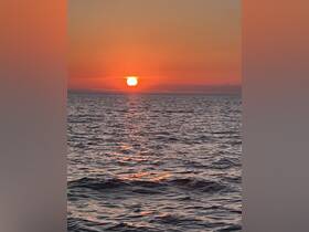 A stunning sunset over the ocean, casting vibrant colors across the water — perfect for romantic evenings or peaceful reflections at sea.