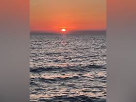 A stunning sunset over the ocean, casting vibrant hues across the water — perfect for serene evening boat cruises.