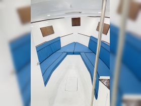 Interior view of a boat cabin featuring comfortable blue seating, ideal for relaxing during trips on the water.