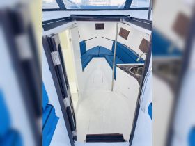 Interior view of a boat cabin featuring comfortable seating and a clean layout, perfect for relaxing during your maritime adventures.
