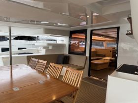 Interior view of a spacious boat cabin featuring a dining area and lounge, perfect for relaxing and entertaining while on the water.