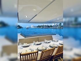 Elegant dining setup on a yacht, featuring a beautifully arranged table with fine dinnerware and a stunning waterfront view — perfect for upscale dining experiences on the water.