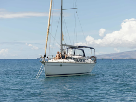 A couple enjoys a relaxing moment aboard a sailboat in the open ocean, perfect for a serene sailing experience.