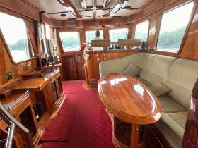 Inside view of a luxurious boat cabin featuring a spacious seating area and helm, perfect for relaxing or navigating on the water.