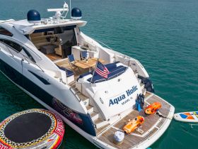 The luxurious yacht 'Aqua Holic' showcases an array of amenities, including kayaks and a paddleboard, perfect for water activities in Miami's beautiful waters.