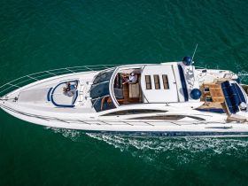 Aerial view of a luxurious yacht in motion, showcasing guests enjoying the ride — perfect for upscale boating experiences.