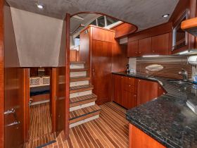 Interior view of a well-appointed boat cabin featuring elegant wood finishes and a functional layout, ideal for comfortable cruising.