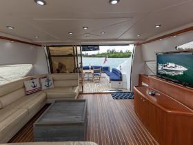Interior view of a luxurious boat cabin featuring comfortable seating and a modern entertainment setup, perfect for relaxing while enjoying scenic views on the water.