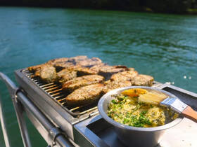Delicious grilled fish and a bowl of flavorful marinade prepared on a boat, perfect for a memorable dining experience on the water.