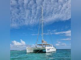 A stunning view of the catamaran 'Dawn' anchored in crystal-clear waters, showcasing its sleek design against a backdrop of blue skies and fluffy clouds.