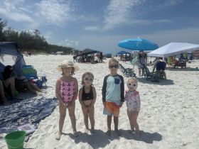 A group of children enjoying a sunny day at the beach, showcasing summer fun and family bonding in a vibrant outdoor setting.