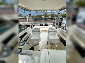 A clean and modern helm area of a boat featuring comfortable seating and essential controls, perfect for navigating the waters.