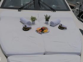 A beautifully arranged spread of snacks and towels on the deck of a yacht, featuring captain's hats, perfect for a luxurious day on the water.
