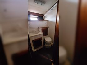 Interior view of a boat bathroom featuring a sink and toilet, showcasing the compact design typical of marine cabins.