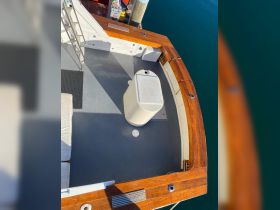 An overhead view of the interior deck of a boat, showcasing the seating area and storage, perfect for relaxing while enjoying the water.