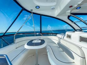 A bright and spacious interior of a Sea Ray boat, showcasing comfortable seating and panoramic views of the water, perfect for relaxing while cruising.