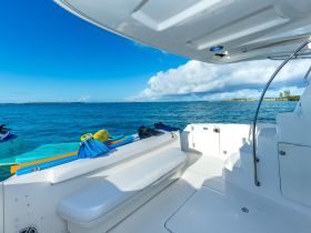 A clean and spacious interior view of a boat's helm area, showcasing comfortable seating and a serene ocean backdrop, perfect for relaxing on the water.