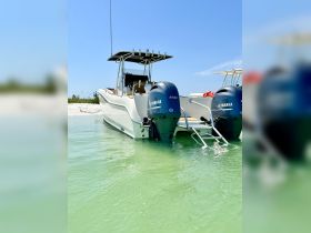 A sleek speedboat anchored in clear green waters, showcasing its powerful Yamaha engines — perfect for thrilling water adventures.