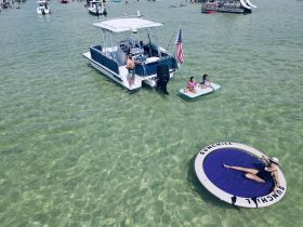 A fun day on the water with family, featuring a pontoon boat and kids enjoying a floating mat — perfect for summer adventures and family outings.