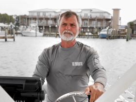 A seasoned captain navigates a boat, showcasing the skill and experience needed for a successful day on the water.