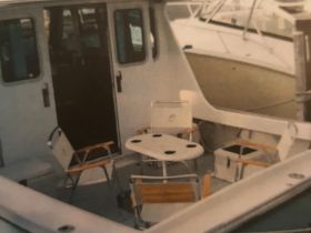 Interior view of a boat's cabin featuring seating and a dining area, perfect for relaxing or enjoying meals while on the water.